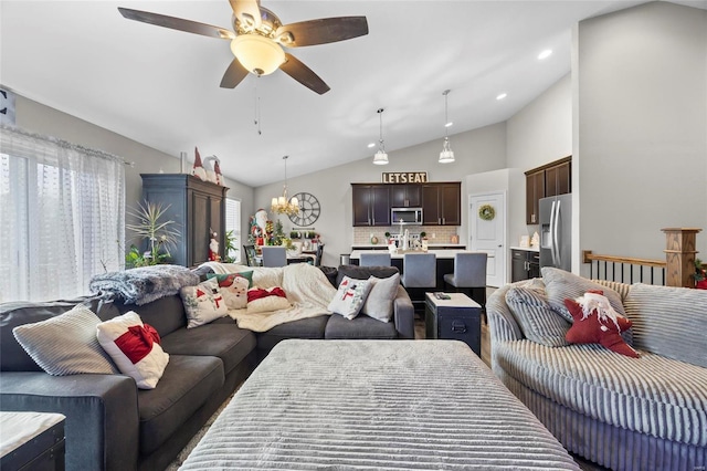 living room with lofted ceiling and ceiling fan with notable chandelier