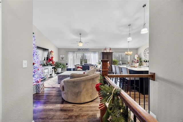 living room featuring hardwood / wood-style flooring and ceiling fan with notable chandelier