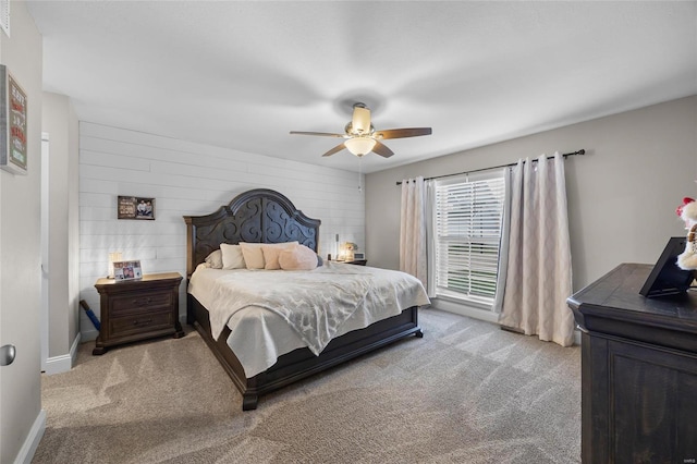 carpeted bedroom with wooden walls and ceiling fan