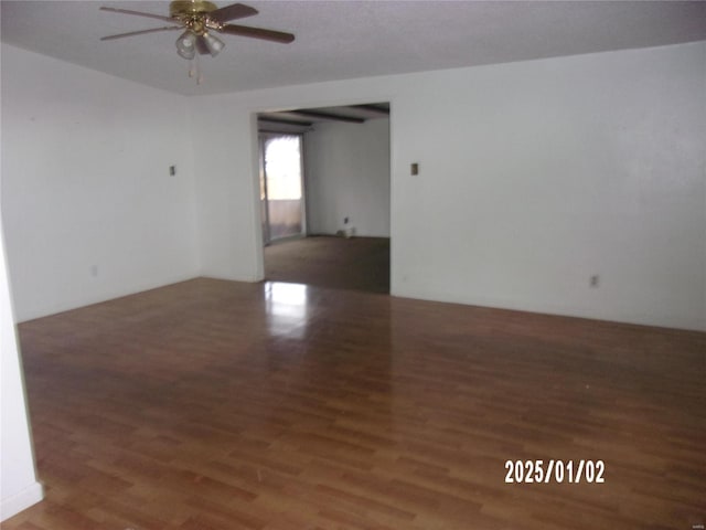 spare room featuring ceiling fan and dark wood-type flooring