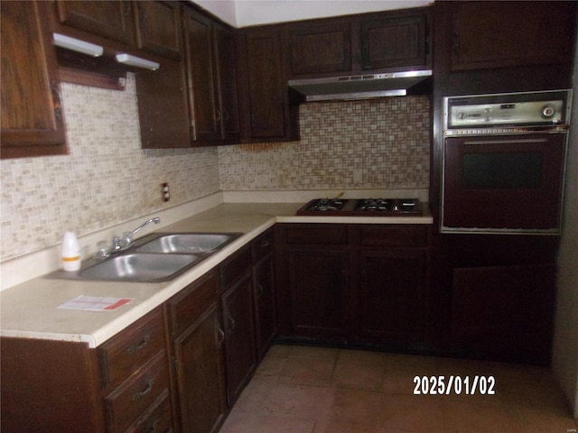 kitchen with ventilation hood, sink, decorative backsplash, black oven, and gas cooktop