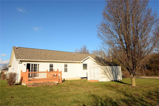 back of house featuring a storage unit, a lawn, and a wooden deck