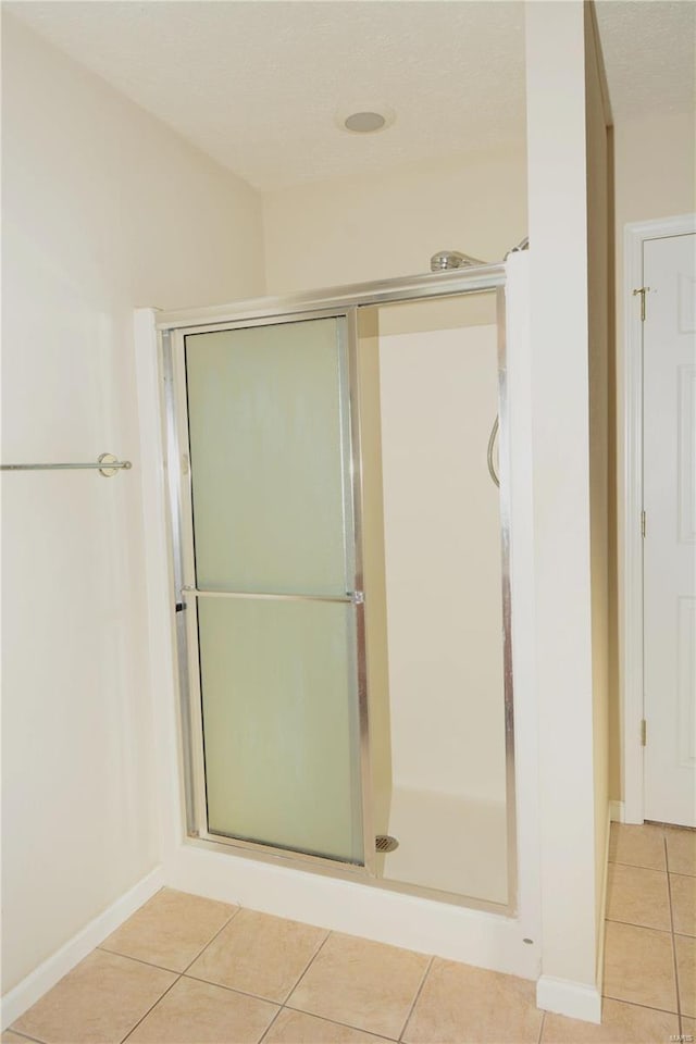 bathroom with tile patterned floors and a shower with shower door