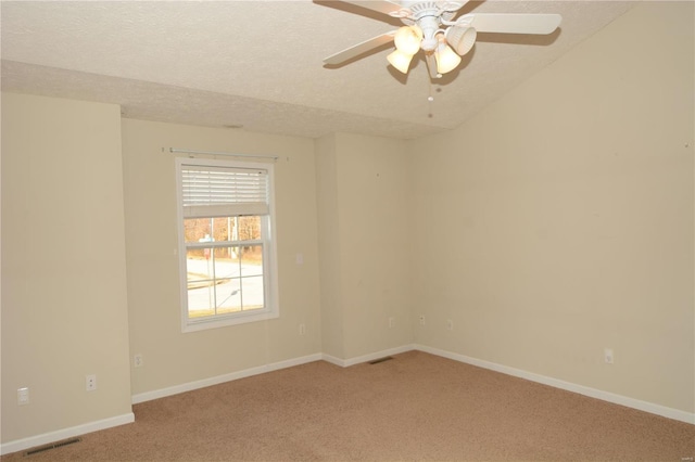 carpeted spare room with ceiling fan and a textured ceiling