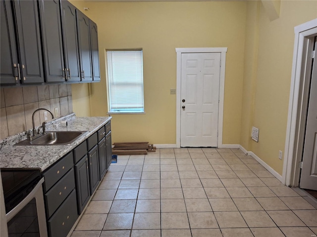 kitchen with tasteful backsplash, light stone counters, sink, light tile patterned floors, and black electric range oven