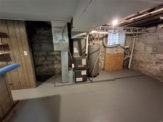 basement with heating unit, wood walls, and gas water heater