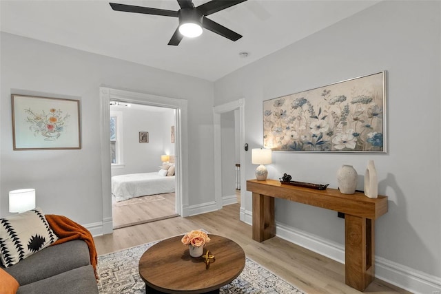 living area with light wood-type flooring and ceiling fan