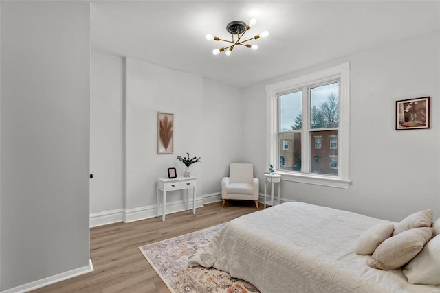 bedroom with hardwood / wood-style flooring and a chandelier