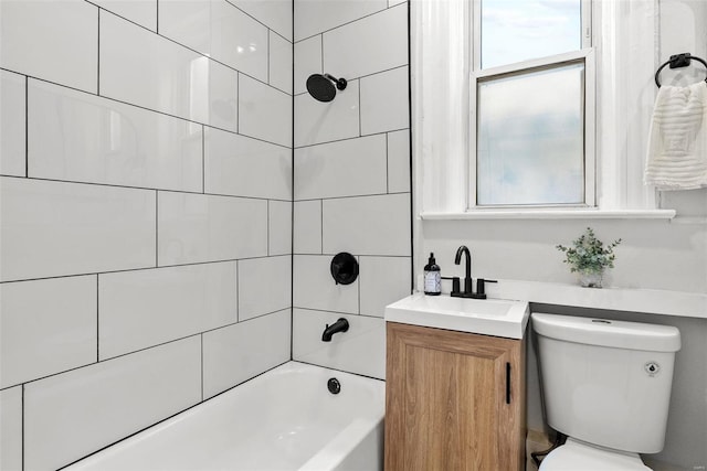 full bathroom featuring vanity, tiled shower / bath combo, and toilet