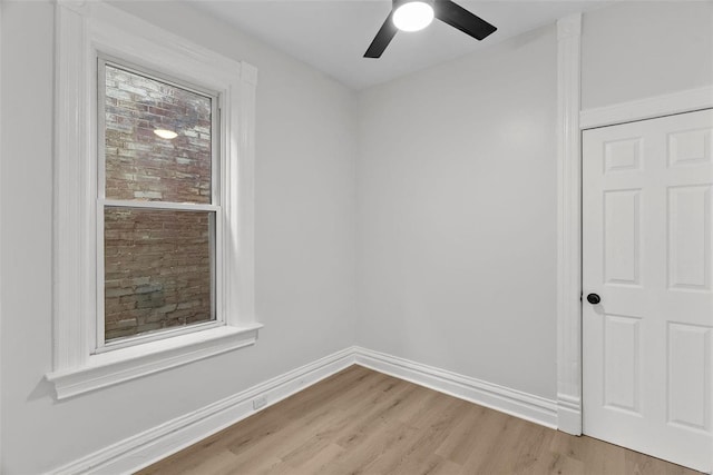 empty room with a wealth of natural light, ceiling fan, and light hardwood / wood-style flooring