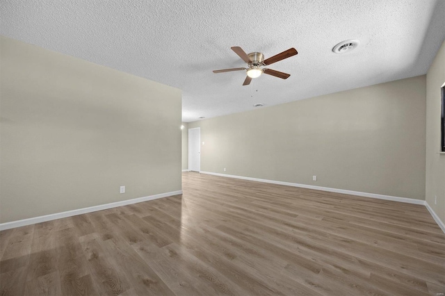 spare room with hardwood / wood-style flooring, ceiling fan, and a textured ceiling