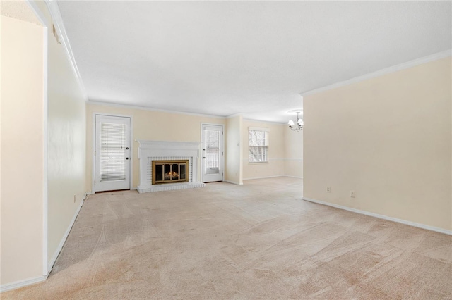 unfurnished living room featuring crown molding, a fireplace, and an inviting chandelier