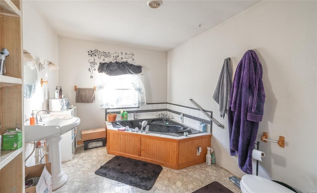 bathroom with a tub to relax in and sink