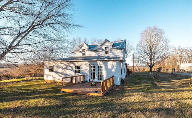 rear view of house with a lawn, a wooden deck, and french doors