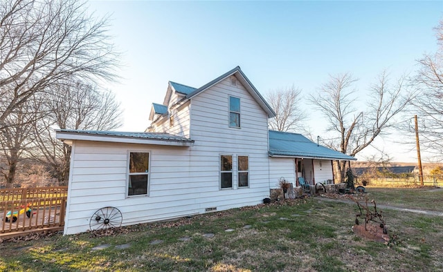 rear view of property featuring a lawn and a wooden deck