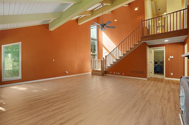 unfurnished living room featuring ceiling fan, beam ceiling, light wood-type flooring, and high vaulted ceiling