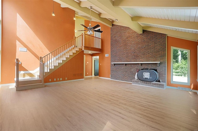 unfurnished living room featuring hardwood / wood-style floors, ceiling fan, beamed ceiling, and high vaulted ceiling