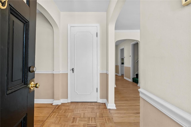 hall with crown molding and light parquet flooring