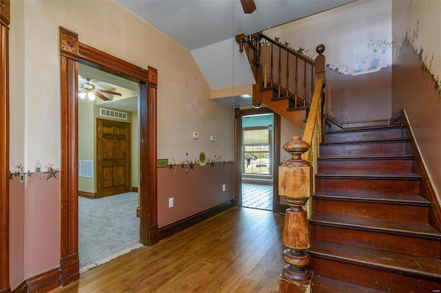 stairway featuring ceiling fan, hardwood / wood-style floors, and vaulted ceiling