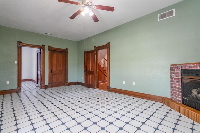 interior space with ceiling fan and a brick fireplace