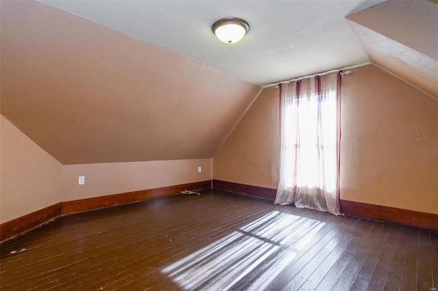 additional living space with dark hardwood / wood-style flooring and lofted ceiling