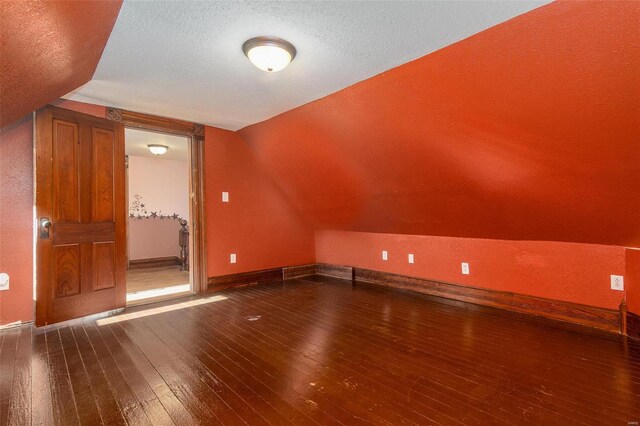 bonus room featuring hardwood / wood-style floors, a textured ceiling, and vaulted ceiling