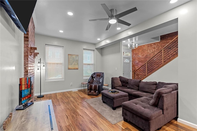 living room featuring hardwood / wood-style floors and ceiling fan with notable chandelier