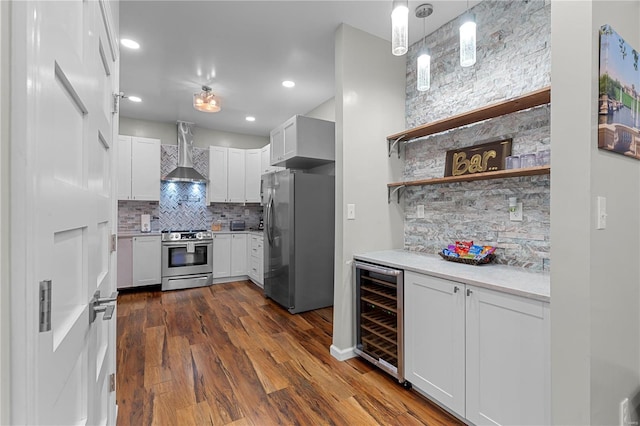 kitchen featuring wall chimney exhaust hood, tasteful backsplash, white cabinetry, stainless steel appliances, and beverage cooler