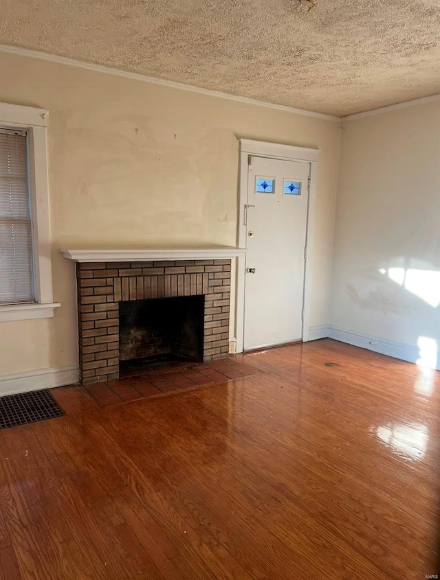 unfurnished living room featuring crown molding, a fireplace, a textured ceiling, and hardwood / wood-style flooring