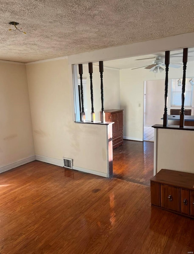 spare room featuring a textured ceiling, ceiling fan, and dark wood-type flooring