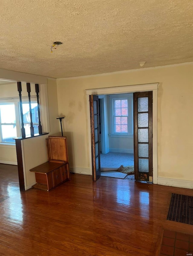 spare room featuring dark hardwood / wood-style floors and a textured ceiling