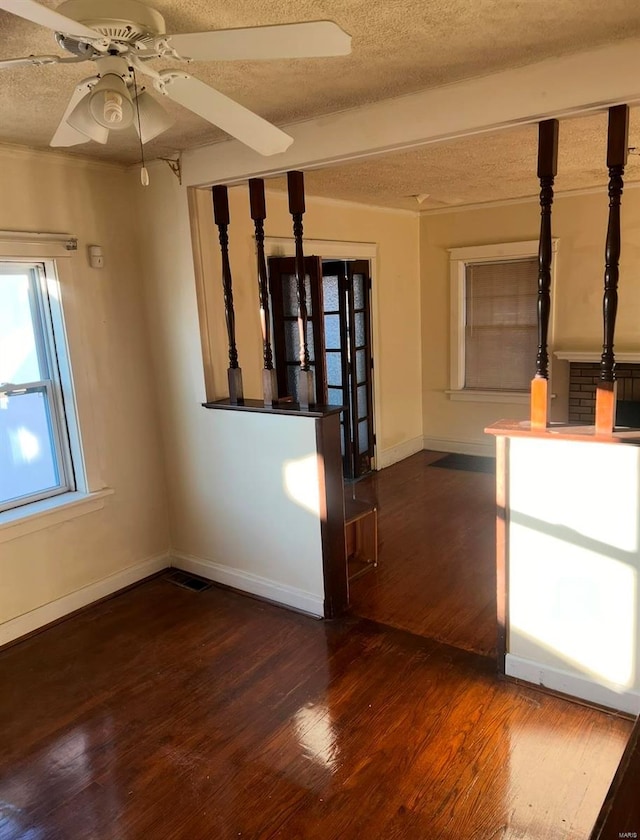 unfurnished living room featuring dark hardwood / wood-style flooring, a textured ceiling, and ceiling fan