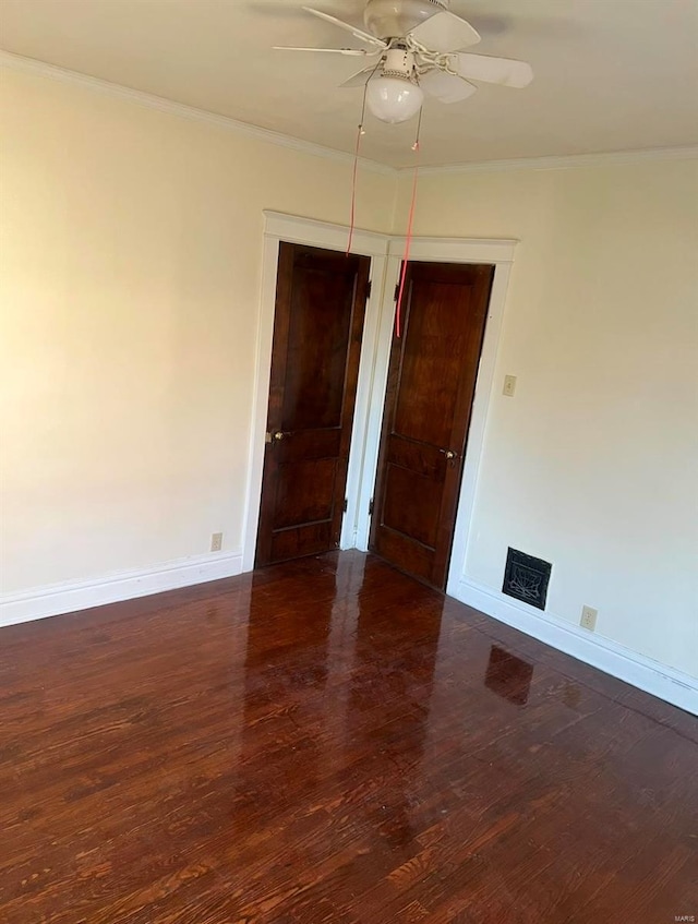 unfurnished room featuring ceiling fan, dark hardwood / wood-style flooring, and ornamental molding