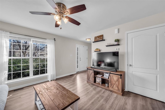 living room with ceiling fan and light hardwood / wood-style flooring