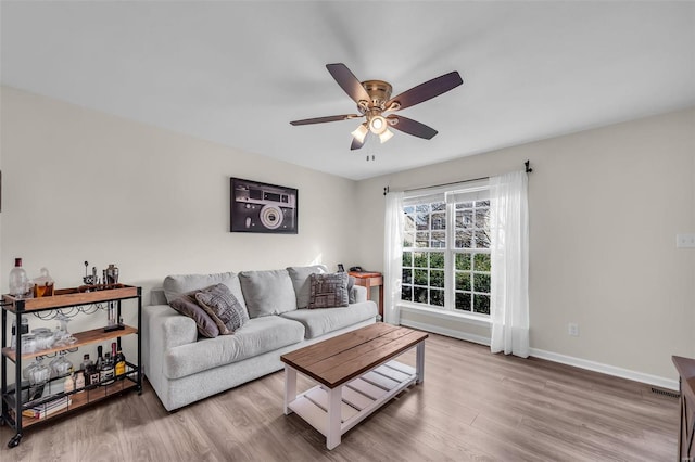 living room with wood-type flooring and ceiling fan