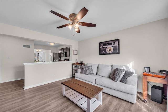 living room with hardwood / wood-style flooring and ceiling fan