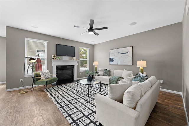 living room with dark hardwood / wood-style flooring and ceiling fan