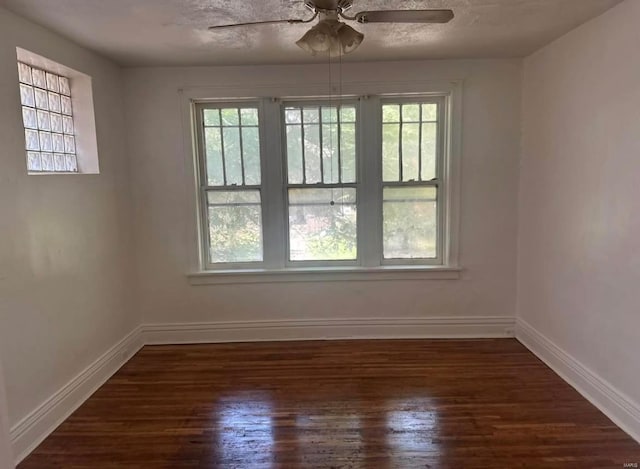 empty room featuring ceiling fan, dark hardwood / wood-style flooring, and a textured ceiling