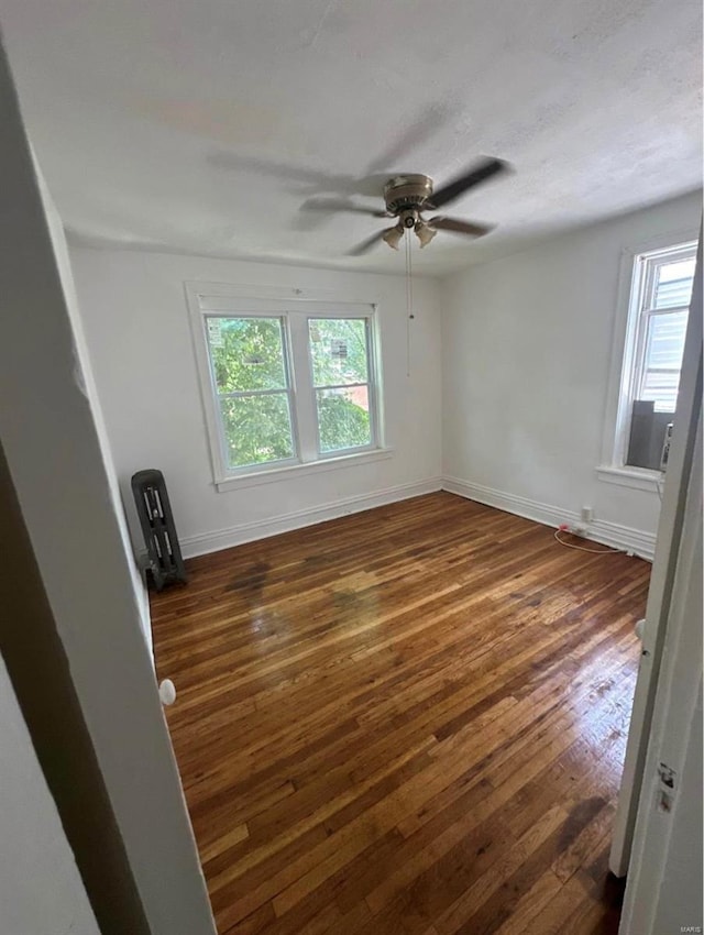 spare room with ceiling fan and dark wood-type flooring