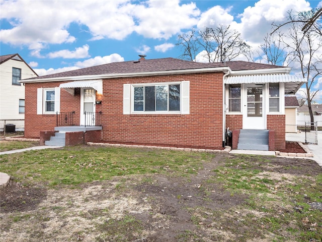 view of front of home with central air condition unit and a front yard