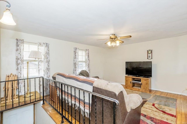 bedroom featuring multiple windows, ceiling fan, and light hardwood / wood-style flooring