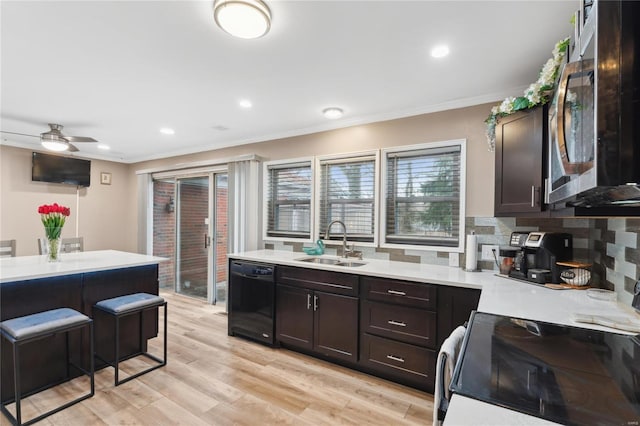 kitchen featuring sink, range with electric stovetop, black dishwasher, light hardwood / wood-style floors, and dark brown cabinetry