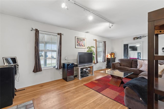 living room with rail lighting, light hardwood / wood-style flooring, and ceiling fan