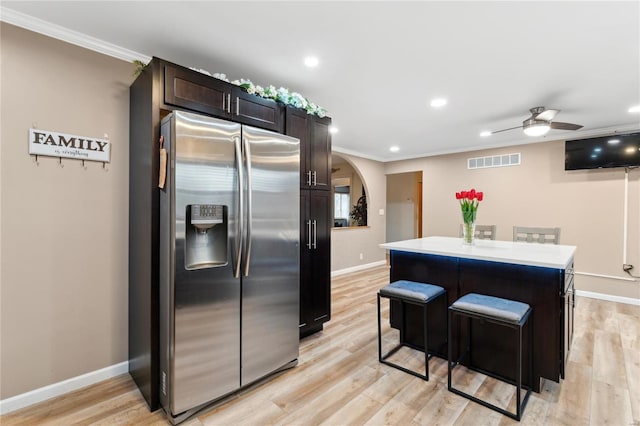 kitchen featuring a center island, stainless steel refrigerator with ice dispenser, ceiling fan, ornamental molding, and light hardwood / wood-style floors