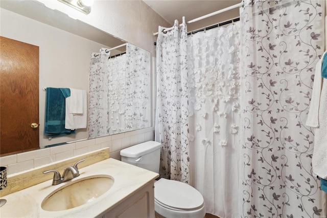 bathroom featuring a shower with shower curtain, vanity, toilet, and tasteful backsplash