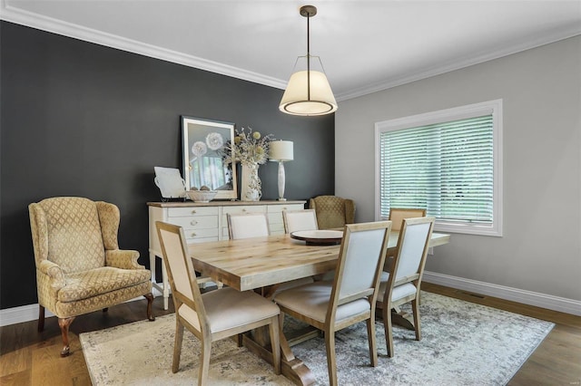 dining space featuring hardwood / wood-style floors and ornamental molding