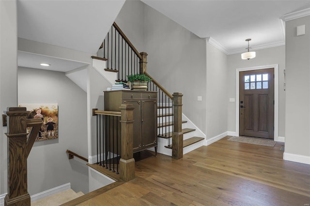 entryway with hardwood / wood-style floors and ornamental molding