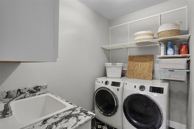 laundry room featuring washing machine and clothes dryer, sink, and cabinets