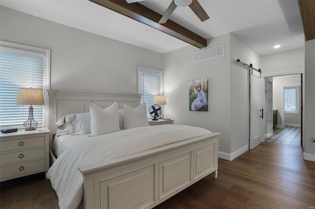 bedroom with beam ceiling, a barn door, dark hardwood / wood-style flooring, and ceiling fan