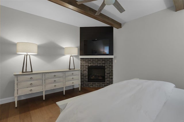 bedroom featuring beam ceiling, ceiling fan, a fireplace, and dark hardwood / wood-style floors